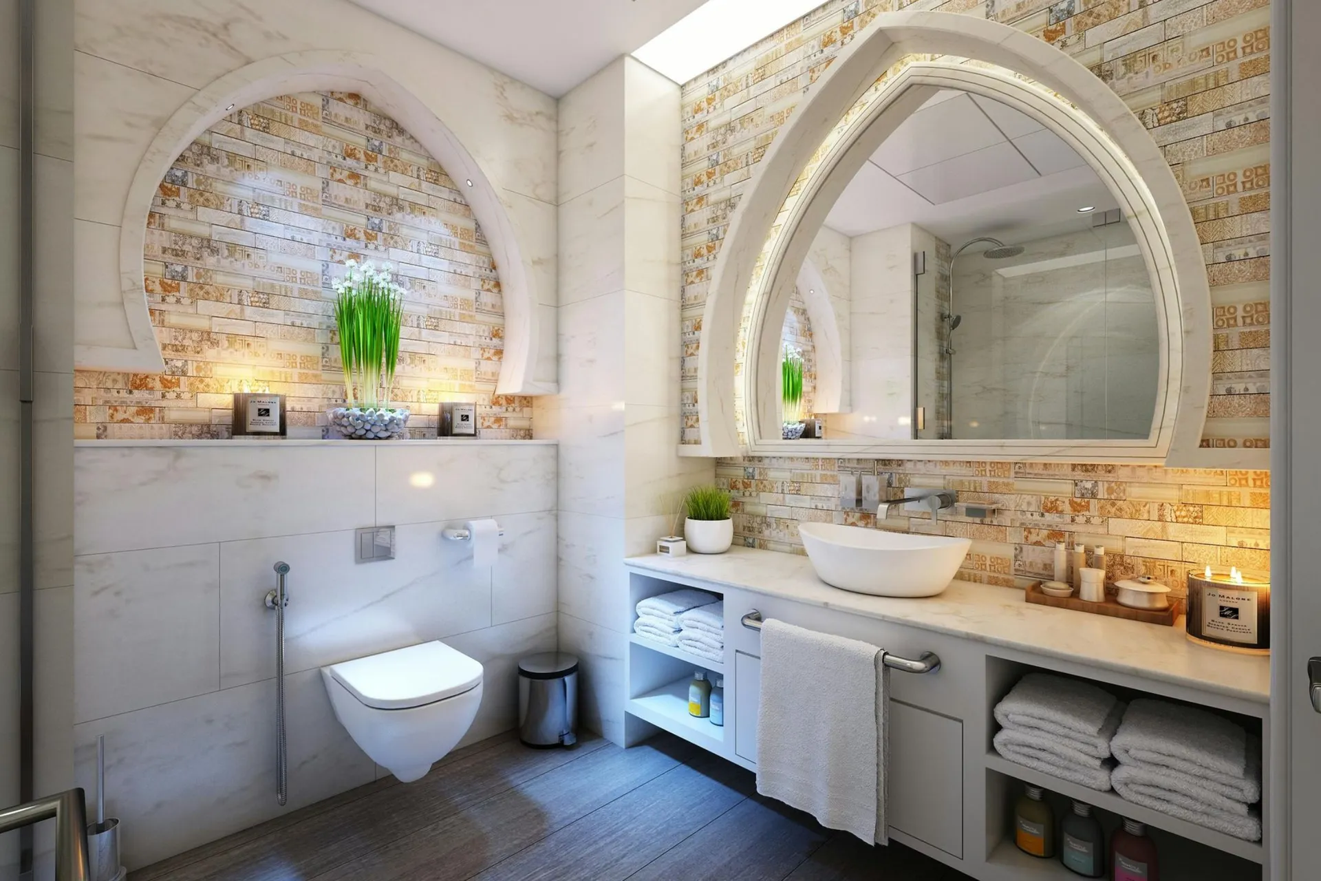 Modern bathroom with arched mirror, illuminated backsplash, vessel sink, and neatly arranged towels on a shelf. A toilet and potted plants enhance